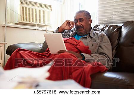 Senior Man Keeping Warm Under Blanket With Photograph View Large Photo Image Stock Photo - Senior Man Keeping Warm Under Blanket With Photograph. Fotosearch
