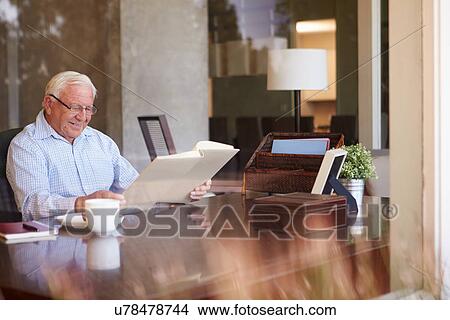Senior Man Looking At Photo Album Through Window View Large Photo Image Picture - Senior Man Looking At Photo Album Through Window. Fotosearch