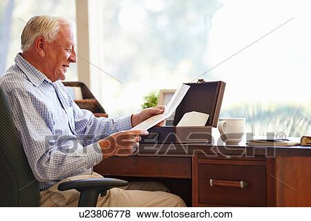 Stock Photo - Senior Man Putting Letter Into Keepsake Box. Fotosearch