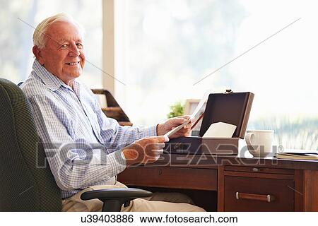 Stock Photograph - Senior Man Putting Letter Into Keepsake Box. Fotosearch