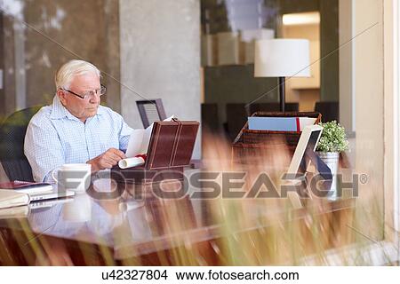 Picture - Senior Man Putting Will Into Box. Fotosearch