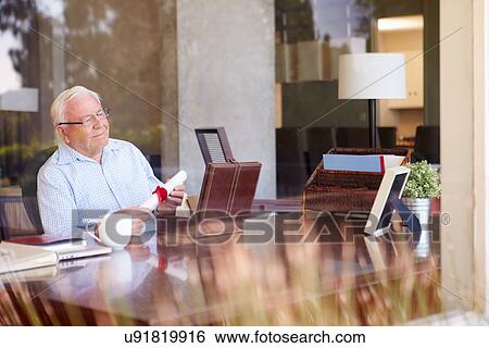 Stock Photograph - Senior Man Putting Will Into Box. Fotosearch