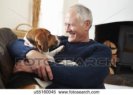 Stock Photography - Senior Man Relaxing At Home With Pet Dog. Fotosearch