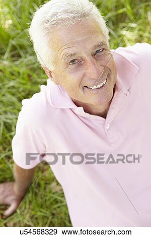 Senior man sitting on grass View Large Photo Image Stock Photo - Senior man sitting on grass. Fotosearch
