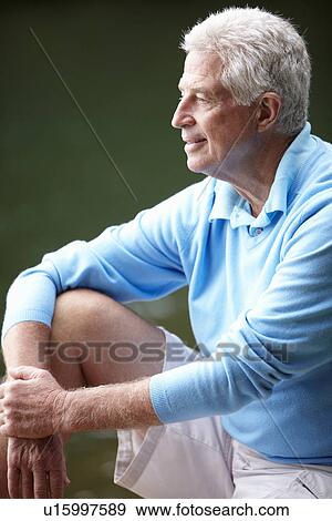 Stock Photo - Senior man sitting outdoors. Fotosearch