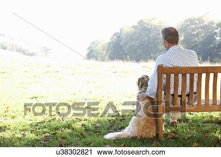 Senior man sitting outdoors with dog View Large Photo Image Stock Image - Senior man sitting outdoors with dog. Fotosearch