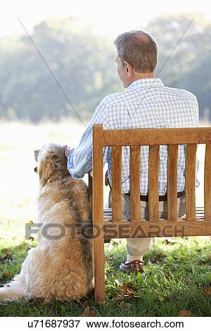 Senior man sitting outdoors with dog View Large Photo Image Stock Photo - Senior man sitting outdoors with dog. Fotosearch
