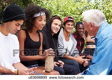 Stock Photo - Senior Man Talking With Gang Of Young People. Fotosearch