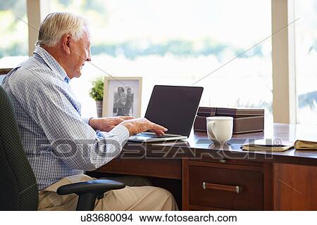 Senior Man Using Laptop On Desk At Home View Large Photo Image Picture - Senior Man Using Laptop On Desk At Home. Fotosearch