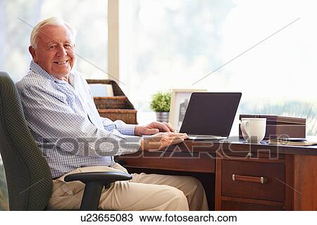 Senior Man Using Laptop On Desk At Home View Large Photo Image Stock Image - Senior Man Using Laptop On Desk At Home. Fotosearch