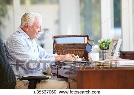 Senior Man Using Laptop On Desk At Home View Large Photo Image Stock Image - Senior Man Using Laptop On Desk At Home. Fotosearch
