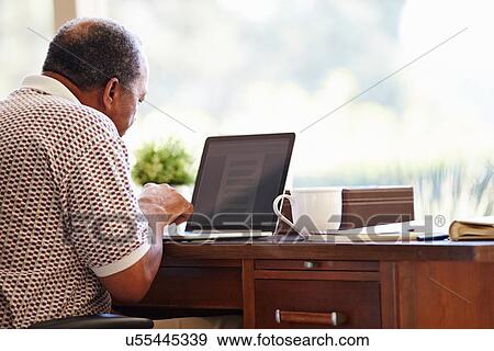 Senior Man Using Laptop On Desk At Home View Large Photo Image Stock Photo - Senior Man Using Laptop On Desk At Home. Fotosearch