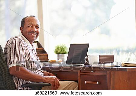 Senior Man Using Laptop On Desk At Home View Large Photo Image Stock Photo - Senior Man Using Laptop On Desk At Home. Fotosearch