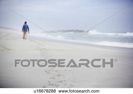 Stock Photo - Senior man walking on beach. Fotosearch