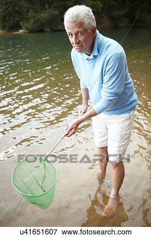 Senior man with fishing net View Large Photo Image Stock Photo - Senior man with fishing net. Fotosearch