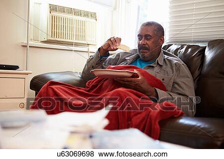 Stock Photo - Senior Man With Poor Diet Keeping Warm Under Blanket . Fotosearch