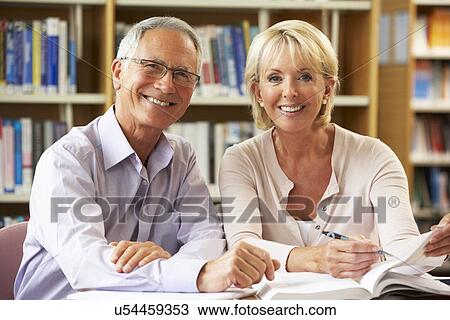 Stock Image - Senior students working in library. Fotosearch