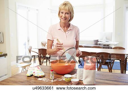 Stock Image - Senior Woman Baking In Kitchen. Fotosearch