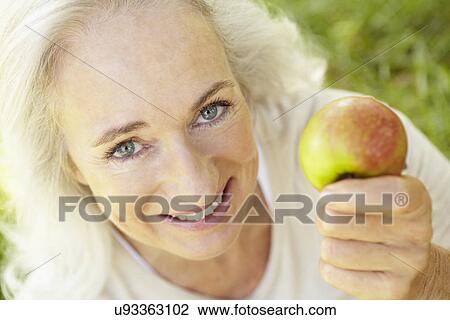 Senior woman eating apple outdoors View Large Photo Image Stock Image - Senior woman eating apple outdoors. Fotosearch