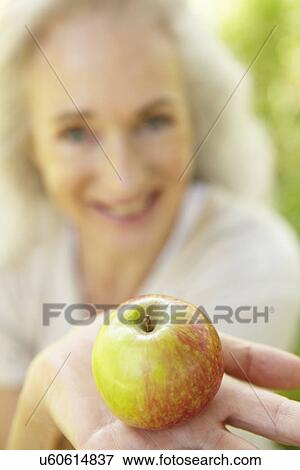 Senior woman eating apple outdoors View Large Photo Image Stock Photo - Senior woman eating apple outdoors. Fotosearch