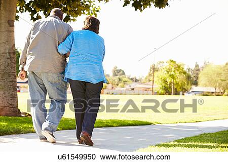 Senior Woman Helping Husband As They Walk In Park Together View Large Photo Image Stock Image - Senior Woman Helping Husband As They Walk In Park Together. Fotosearch