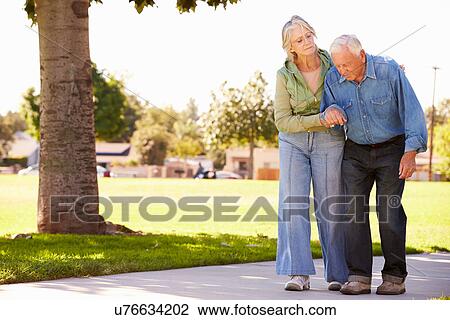 Senior Woman Helping Husband As They Walk In Park Together View Large Photo Image Stock Image - Senior Woman Helping Husband As They Walk In Park Together. Fotosearch