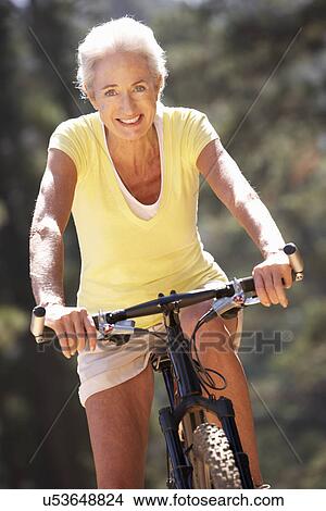 Picture - Senior woman on country bike ride. Fotosearch