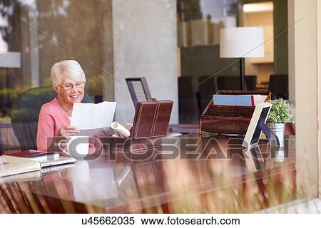 Stock Photography - Senior Woman Putting Letter Into Keepsake Box. Fotosearch