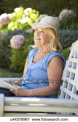 Senior woman reading in garden View Large Photo Image Stock Photo - Senior woman reading in garden. Fotosearch