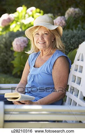 Senior woman reading in garden View Large Photo Image Stock Photograph - Senior woman reading in garden. Fotosearch