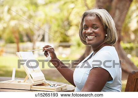 Senior Woman Sitting At Outdoor Table Painting Landscape View Large Photo Image Stock Image - Senior Woman Sitting At Outdoor Table Painting Landscape. Fotosearch