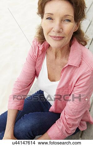 Senior woman sitting by beach View Large Photo Image Picture - Senior woman sitting by beach. Fotosearch