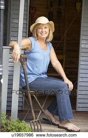 Stock Photograph - Senior woman sitting on veranda. Fotosearch