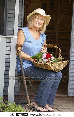 Senior woman sitting on veranda with flowers View Large Photo Image Stock Image - Senior woman sitting on veranda with flowers. Fotosearch