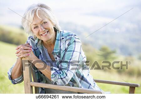 Senior woman sitting outdoors View Large Photo Image Stock Image - Senior woman sitting outdoors. Fotosearch