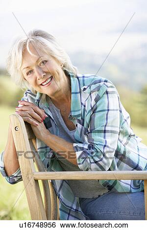 Senior woman sitting outdoors View Large Photo Image Stock Photograph - Senior woman sitting outdoors. Fotosearch