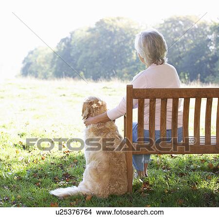 Senior woman sitting outdoors with dog View Large Photo Image Picture - Senior woman sitting outdoors with dog. Fotosearch