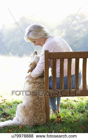 Senior woman sitting outdoors with dog View Large Photo Image Stock Photo - Senior woman sitting outdoors with dog. Fotosearch