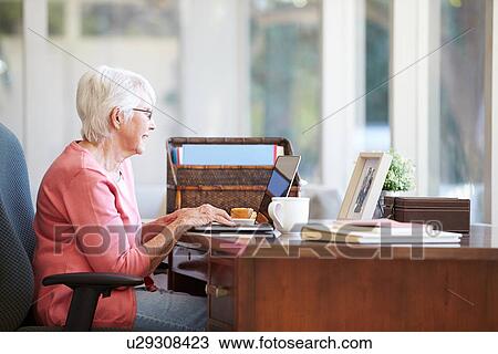 Senior Woman Using Laptop On Desk At Home View Large Photo Image Stock Image - Senior Woman Using Laptop On Desk At Home. Fotosearch