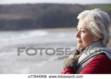 Stock Photo - Senior Woman Walking On Winter Beach. Fotosearch