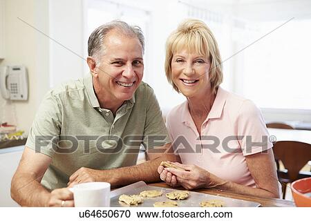 Stock Image - Senior Woman With Husband Baking Cookies In Kitchen. Fotosearch