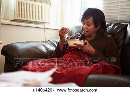 Stock Photo - Senior Woman With Poor Diet Keeping Warm Under Blanket . Fotosearch