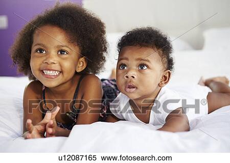 Sister With Baby Brother Lying On Parent's Bed View Large Photo Image Stock Photography - Sister With Baby Brother Lying On Parent's Bed. Fotosearch