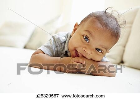 Stock Photo - Smiling Baby Boy Lying On Tummy At Home. Fotosearch