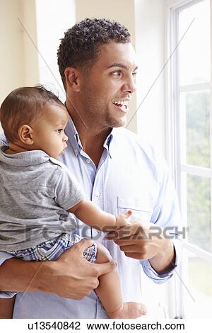 Smiling Father Standing By Window With Baby Son At Home View Large Photo Image Stock Image - Smiling Father Standing By Window With Baby Son At Home. Fotosearch