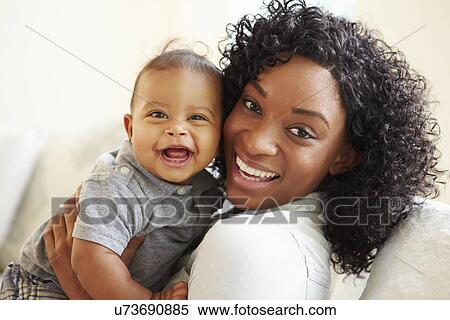 Stock Photography - Smiling Mother Playing With Baby Son At Home. Fotosearch