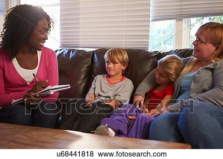 Stock Photo - Social Worker Talking To Mother And Children At Home. Fotosearch