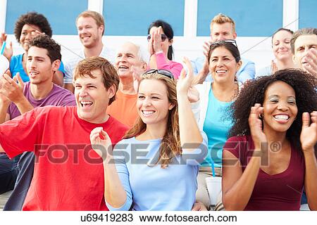 Stock Image - Spectators Cheering At Outdoor Sports Event. Fotosearch