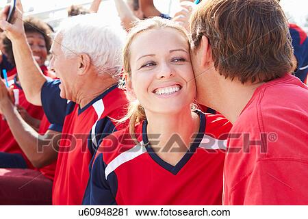 Stock Image - Sports Spectators In Team Colors Celebrating. Fotosearch