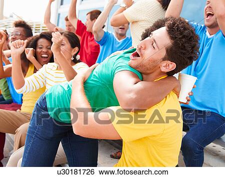 Stock Photograph - Sports Spectators In Team Colors Celebrating. Fotosearch